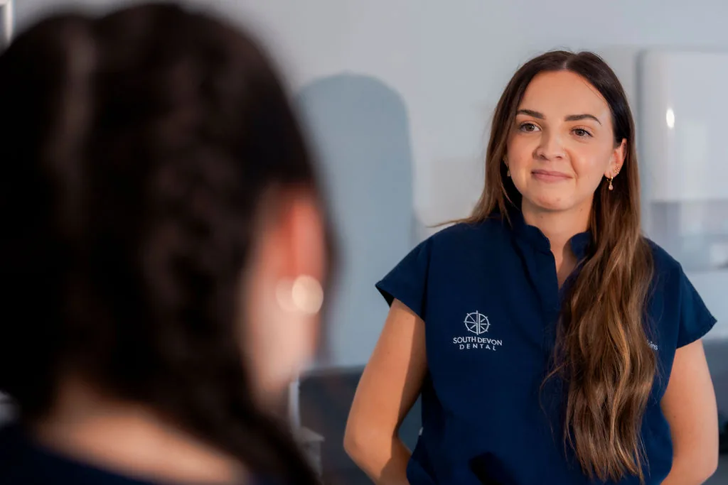 A member of the dental team talking with a patient during an appointment.